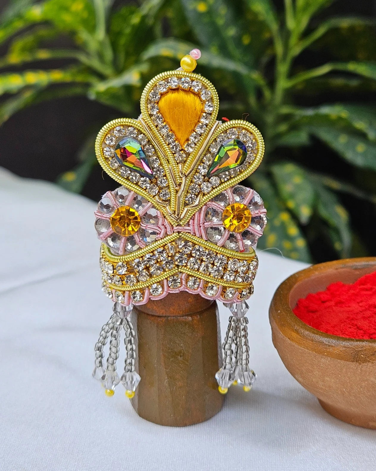 Golden and pink Laddu Gopal Mukut with kundan stones, crystal beads, and pearl tassels – elegant crown for Kanha Ji shringar.