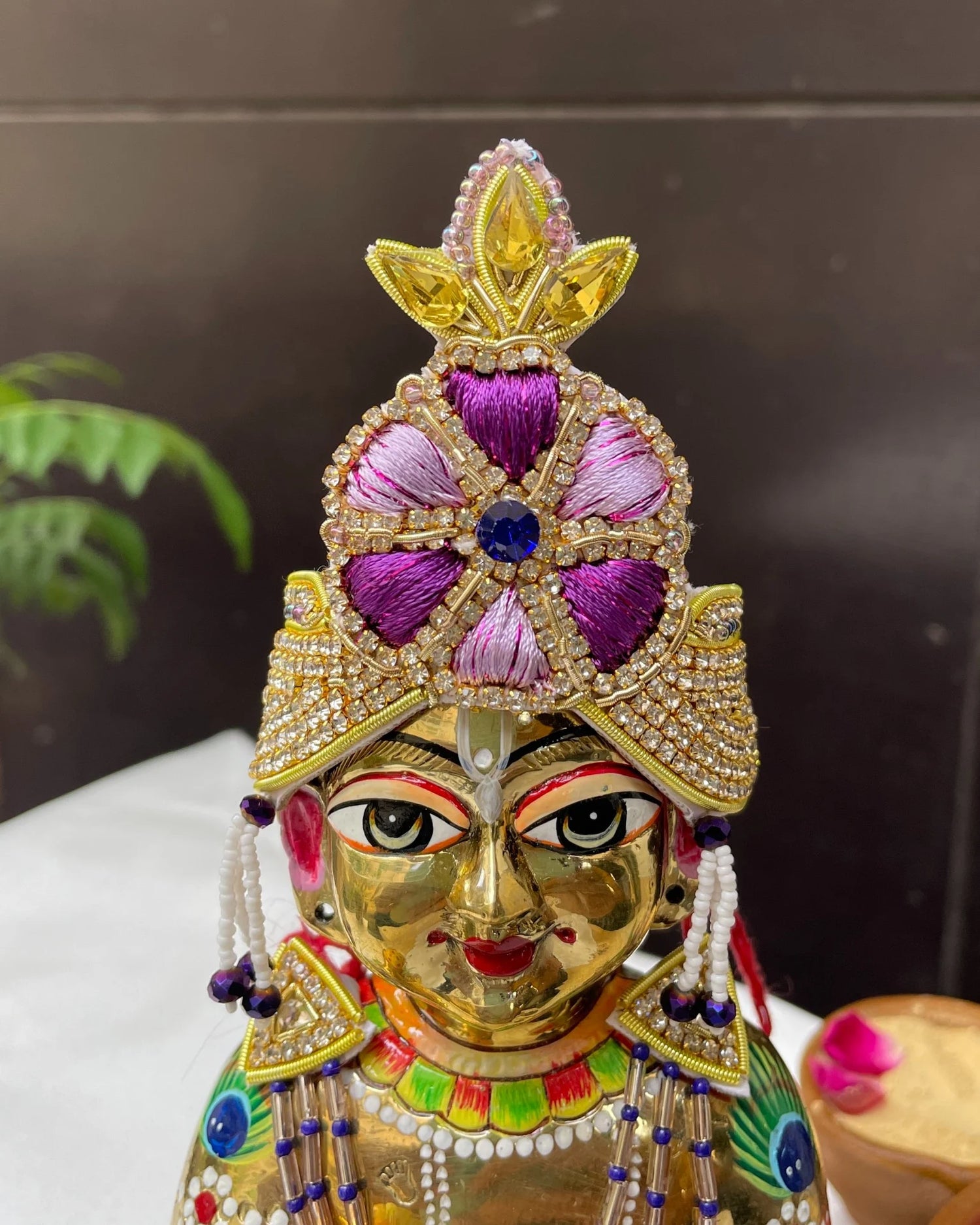 Bal Gopal idol wearing a purple embroidered mukut and layered mala – elegant Laddu Gopal jewellery set for pooja and festive shringar.