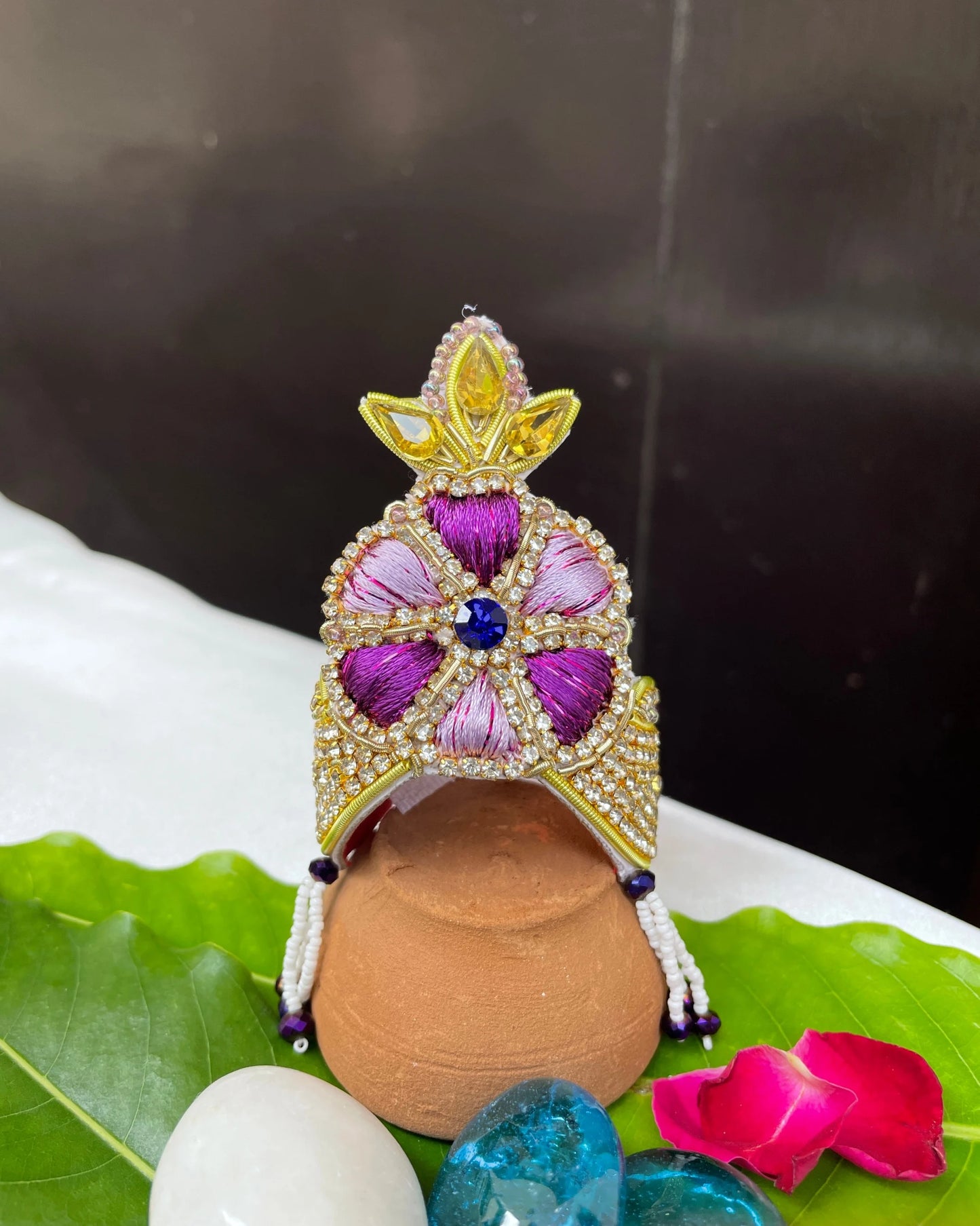 Bal Gopal idol wearing a purple embroidered mukut and layered mala – elegant Laddu Gopal jewellery set for pooja and festive shringar.