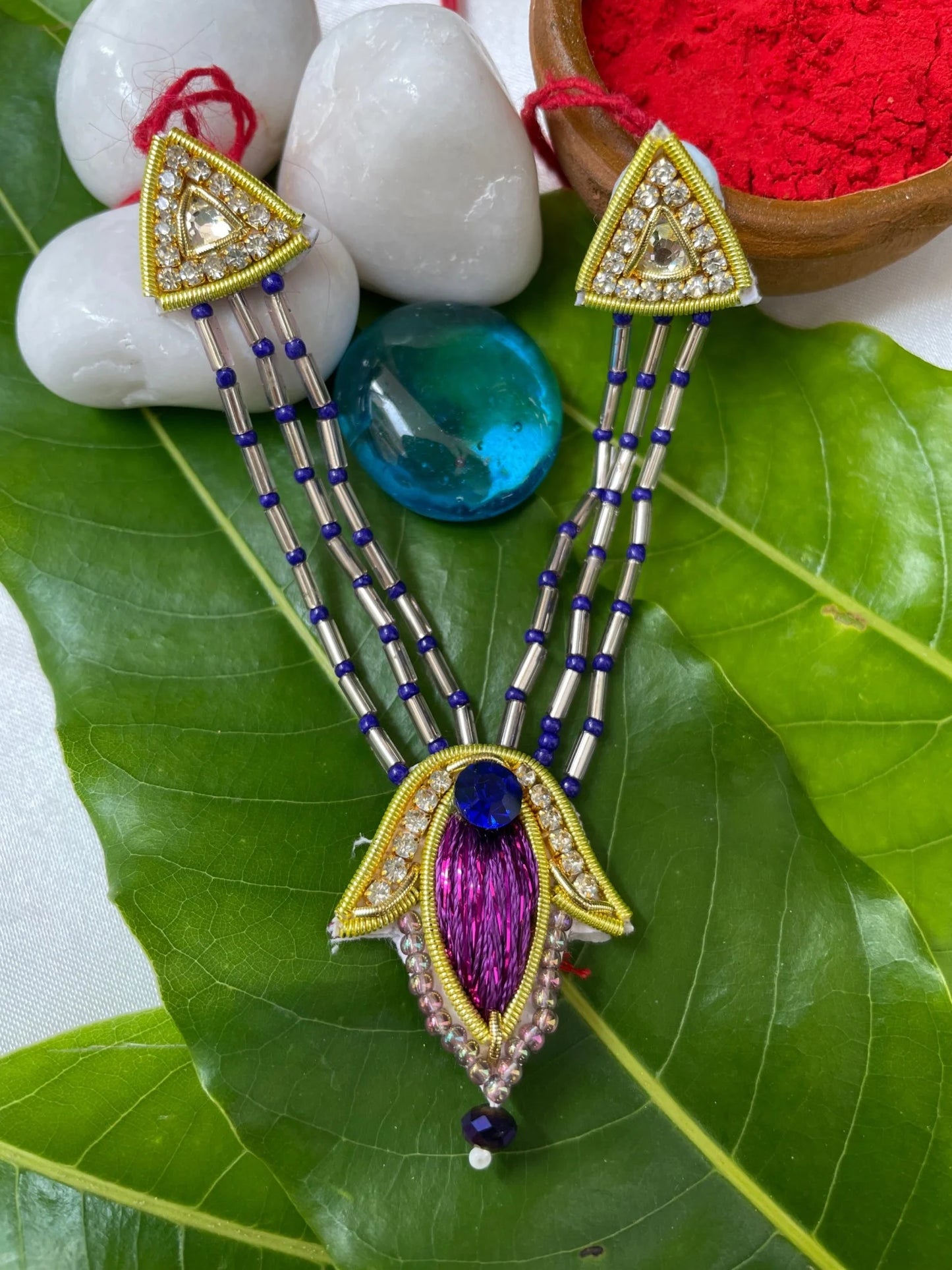 Bal Gopal idol wearing a purple embroidered mukut and layered mala – elegant Laddu Gopal jewellery set for pooja and festive shringar.