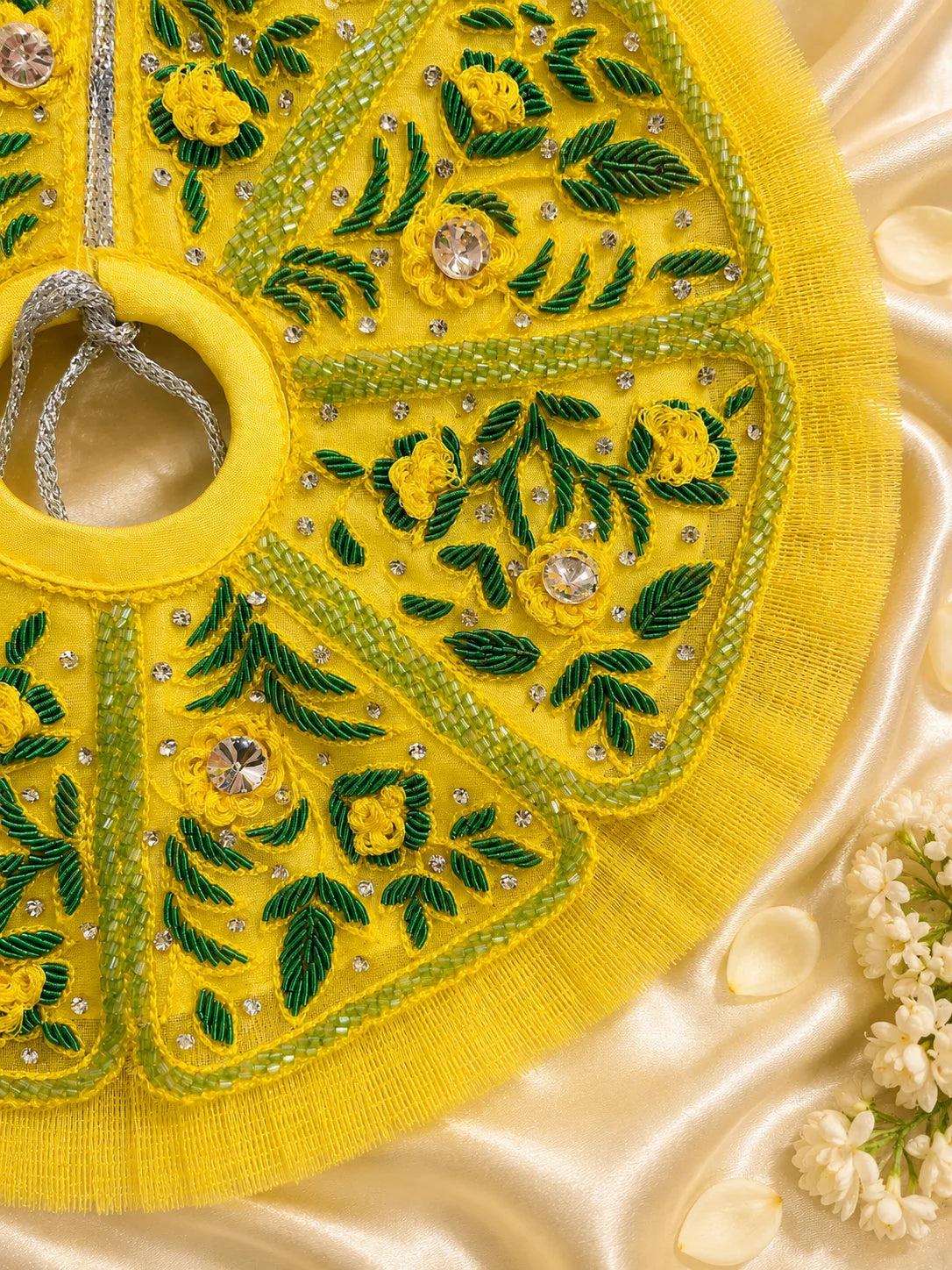 Black stone Laddu Gopal Ji idol adorned in a premium bright yellow dress with green leaf embroidery, sparkling stone work, and a matching heavy yellow turban decorated with green fabric roses