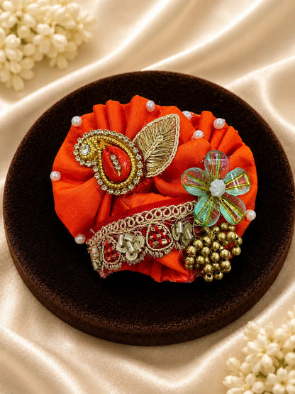 Vibrant orange festive Laddu Gopal poshak set with intricate white pearl beadwork, heavy zardozi embroidery, matching patka, and decorated turban displayed flat on white silk