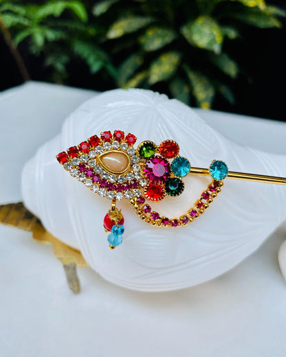 Red and gold crystal-studded Laddu Gopal bansuri with floral centerpiece and hanging beads – divine flute for Kanha Ji shringar.