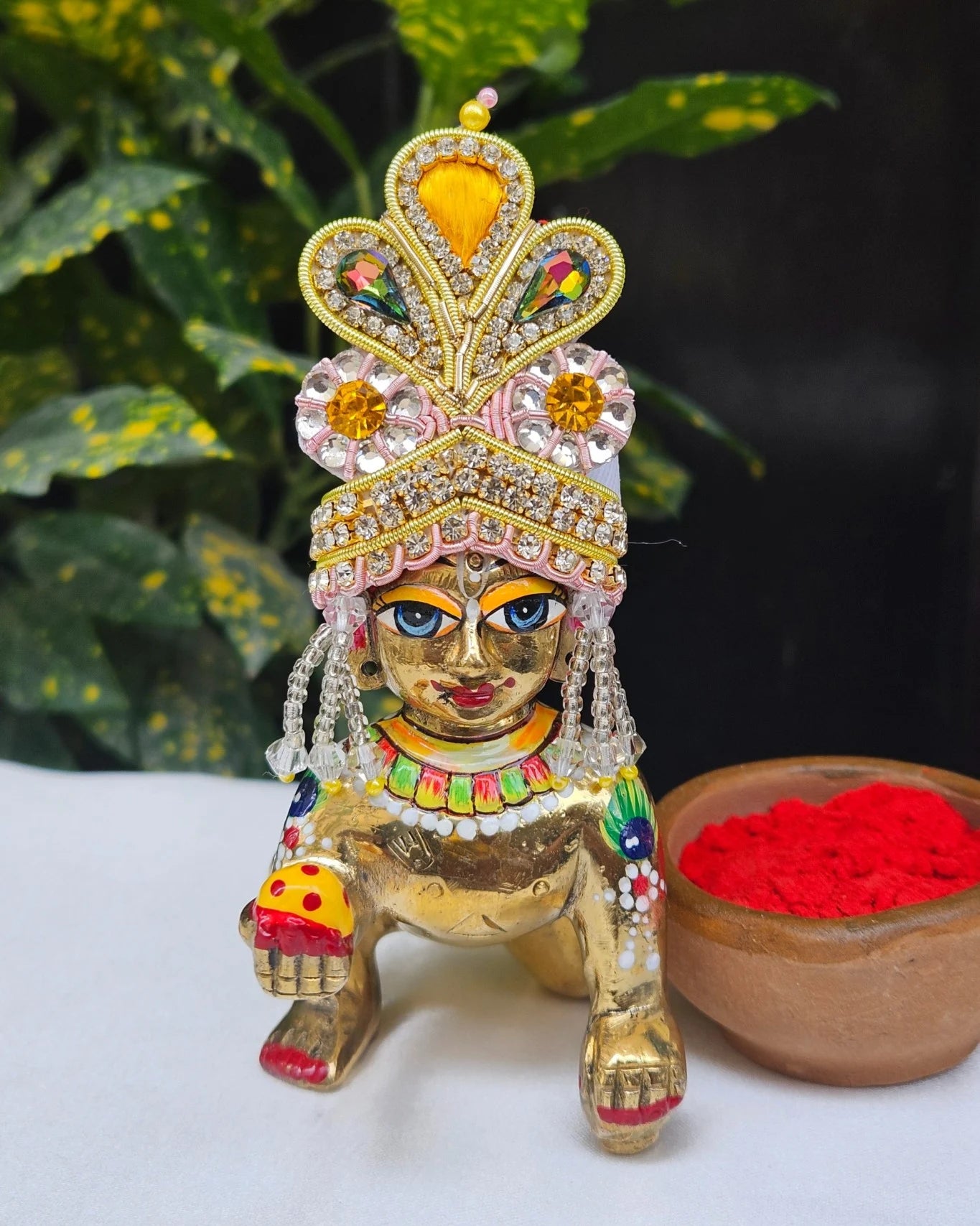 Golden and pink Laddu Gopal Mukut with kundan stones, crystal beads, and pearl tassels – elegant crown for Kanha Ji shringar.