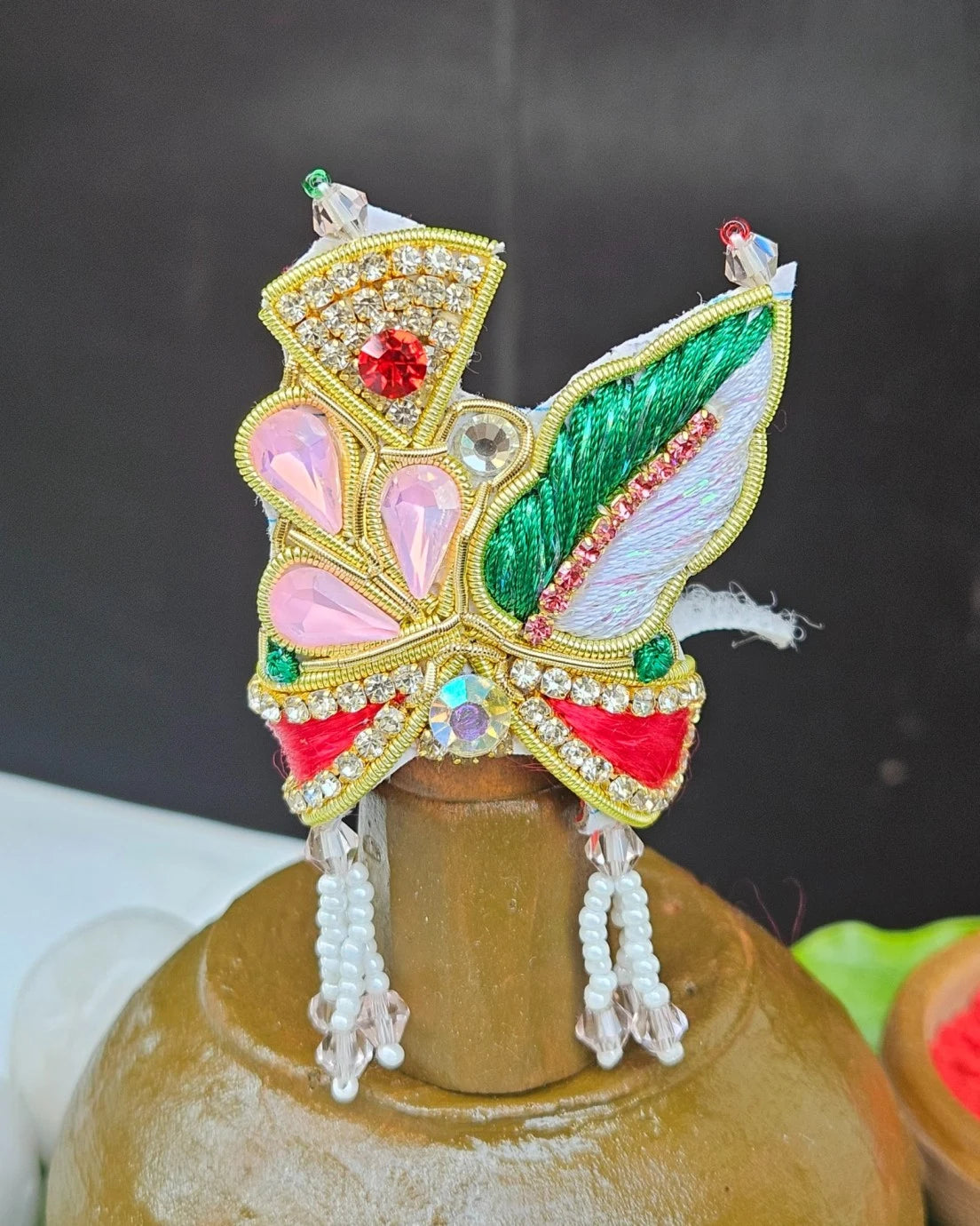 Laddu Gopal red green feather mukut with white bead mala – crown and necklace set for Krishna shringar.