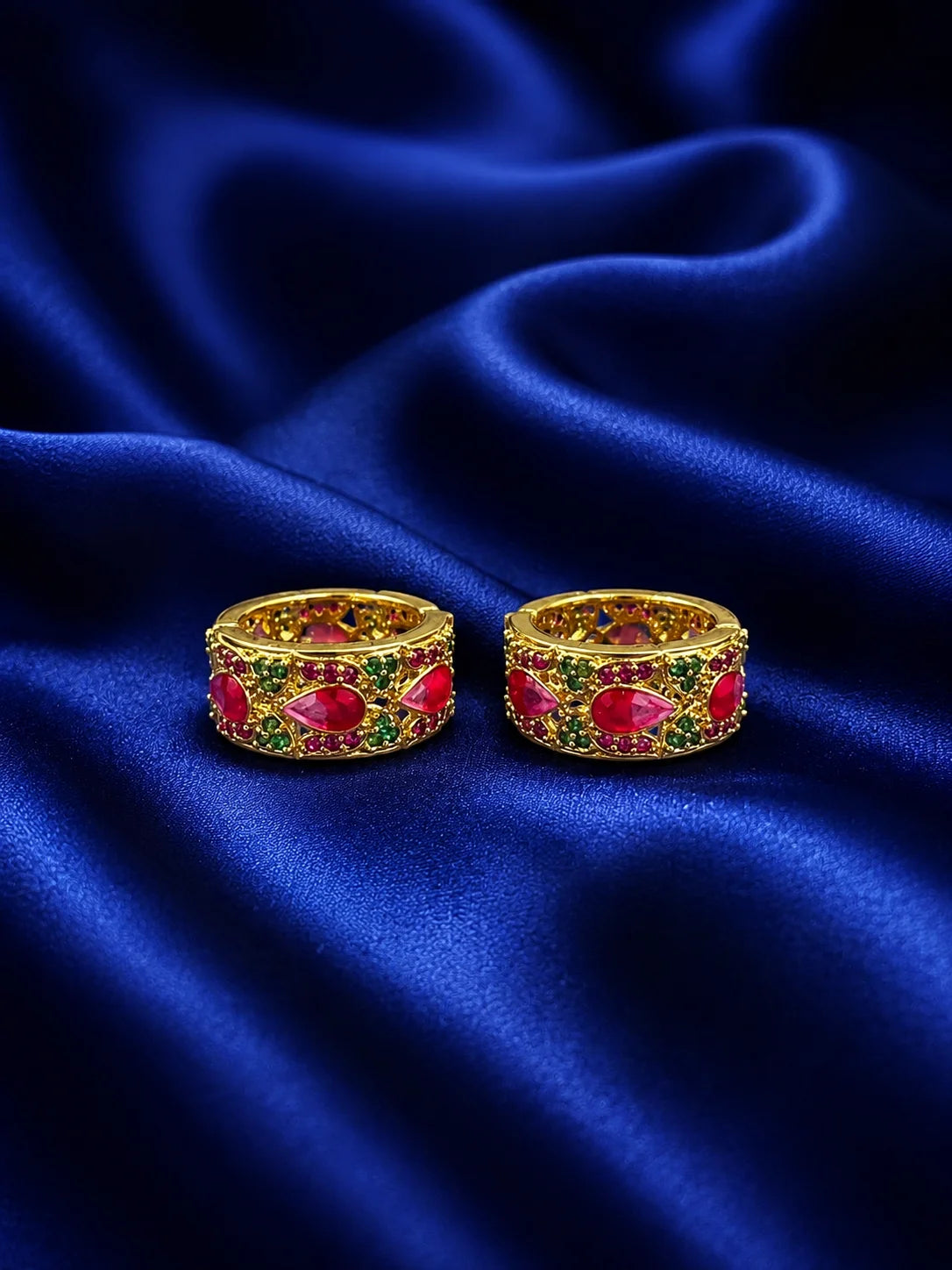 Traditional broad gold deity kada set featuring royal enamel details and glittering white American diamonds over a deep navy blue satin drape 