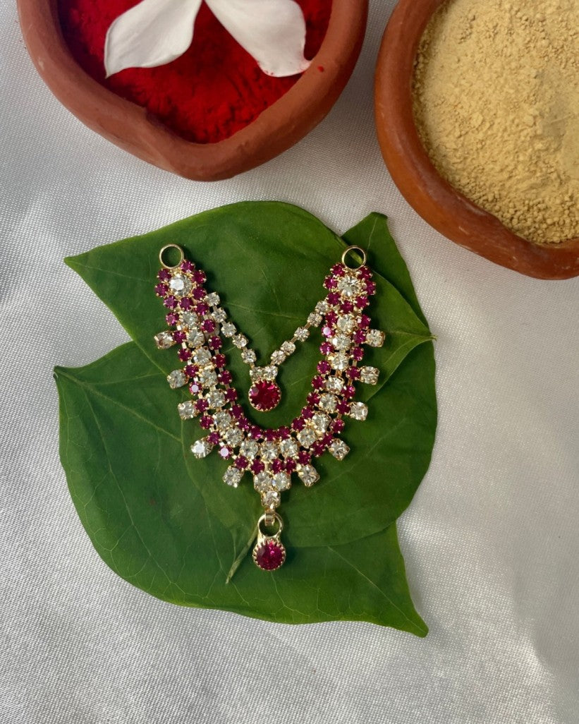 Double-layer pink and white stone Laddu Gopal haar placed on terracotta pot with green leaf and red kumkum.