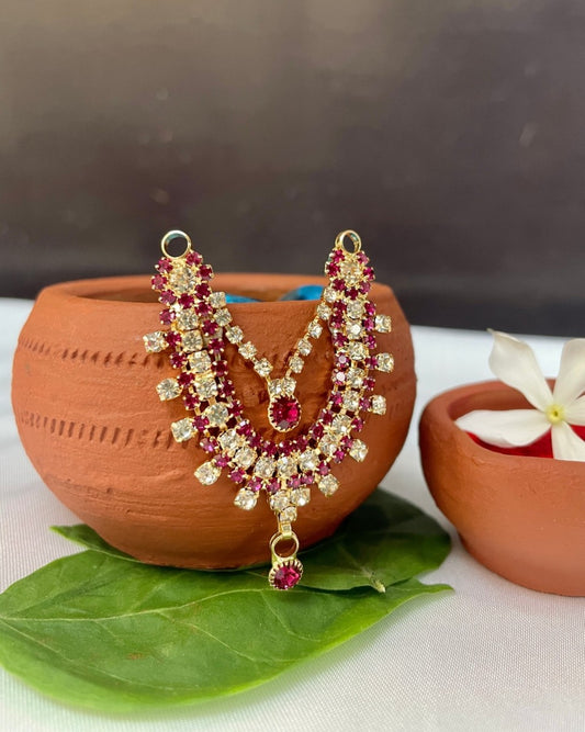 Double-layer pink and white stone Laddu Gopal haar placed on terracotta pot with green leaf and red kumkum.