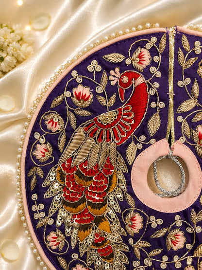 Royal purple Laddu Gopal dress set with detailed silver embroidery, embroidered peacock motif, pearl border, matching patka, and pink flower pagdi turban on white silk fabric