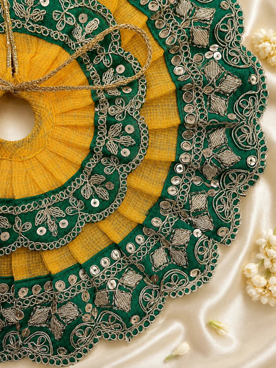 Close Up of Emerald Green Scalloped Metallic Zari Lace and Sequins on Yellow Textured Laddu Gopal Dress

