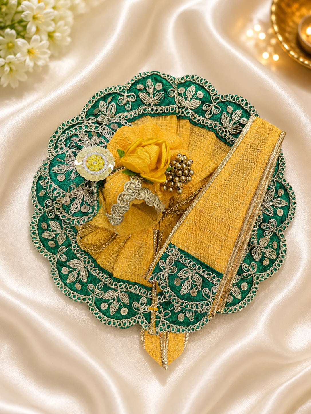 Close Up of Emerald Green Scalloped Metallic Zari Lace and Sequins on Yellow Textured Laddu Gopal Dress


