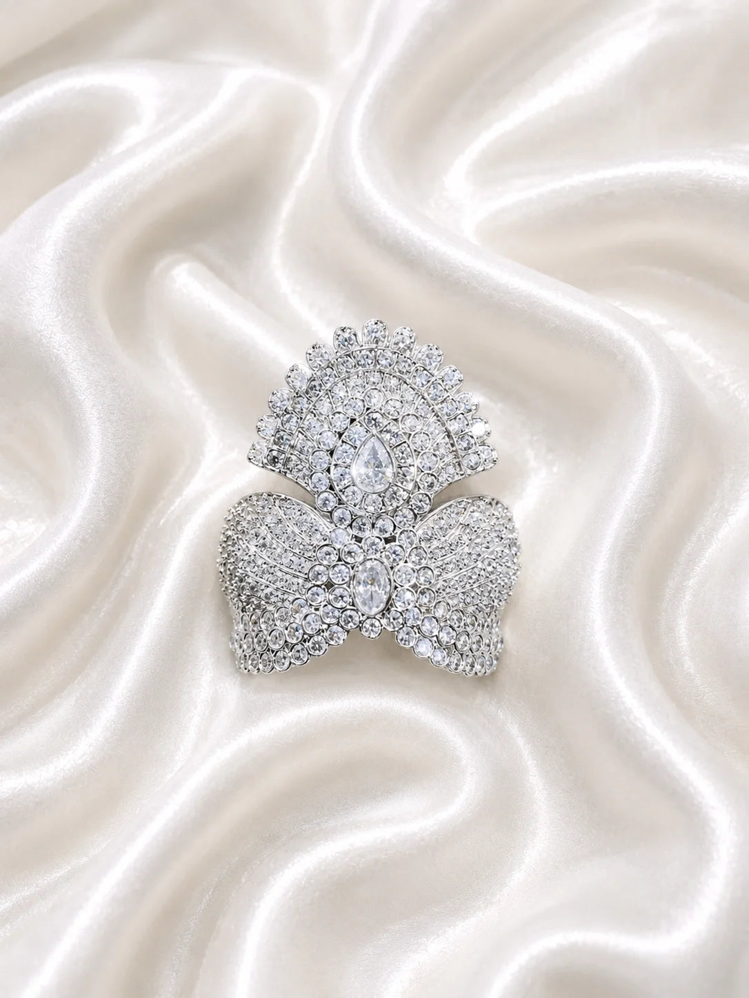 Black brass Laddu Gopal idol adorned with a majestic all-white sparkling diamond silver crown against a soft gold background