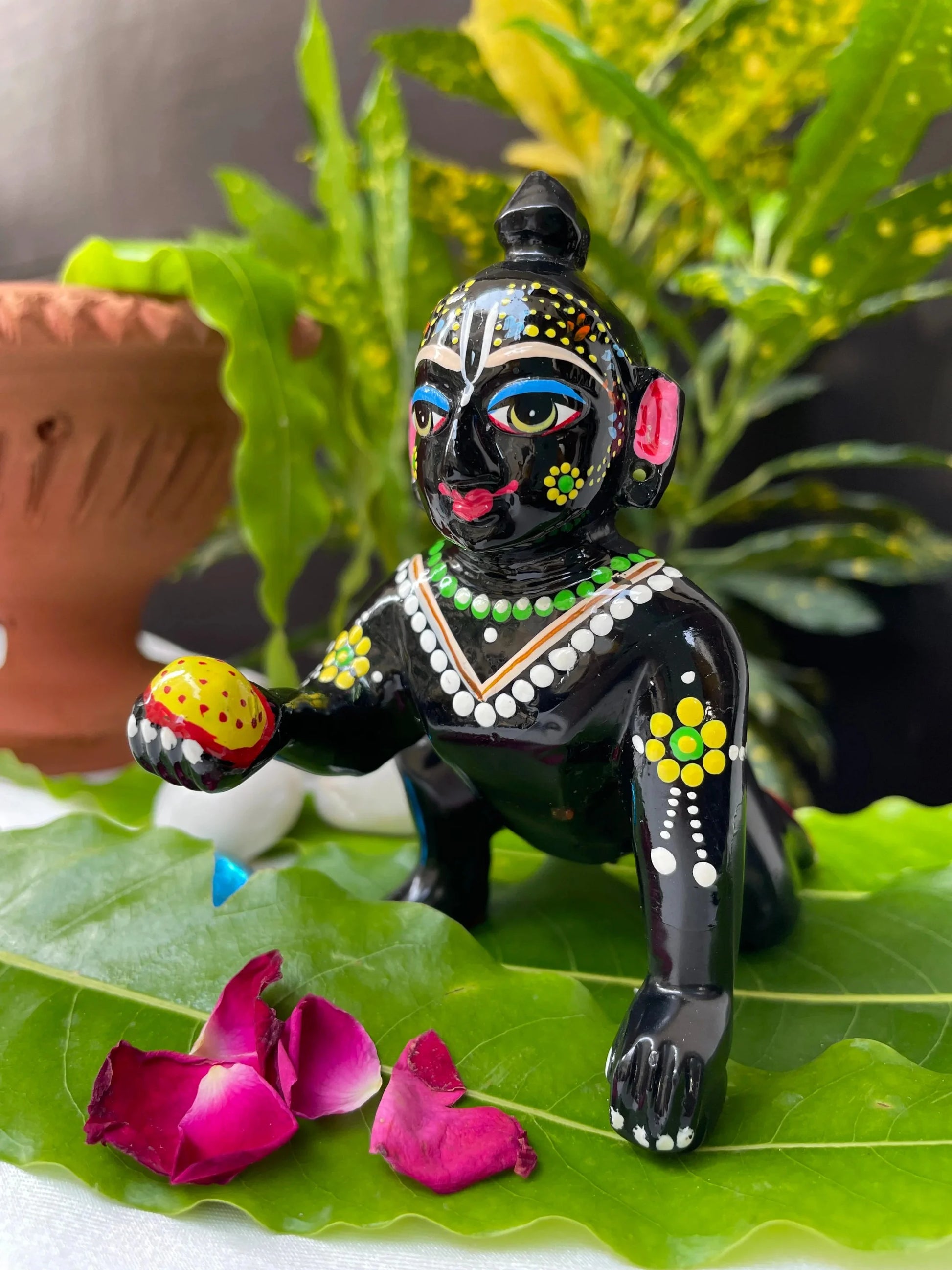 Black Laddu Gopal Vigraha idol holding a laddu – hand-painted brass murti with devotional detailing.