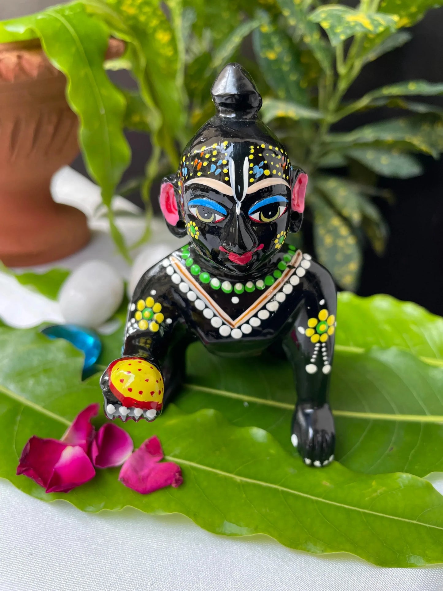 Black Laddu Gopal Vigraha idol holding a laddu – hand-painted brass murti with devotional detailing.
